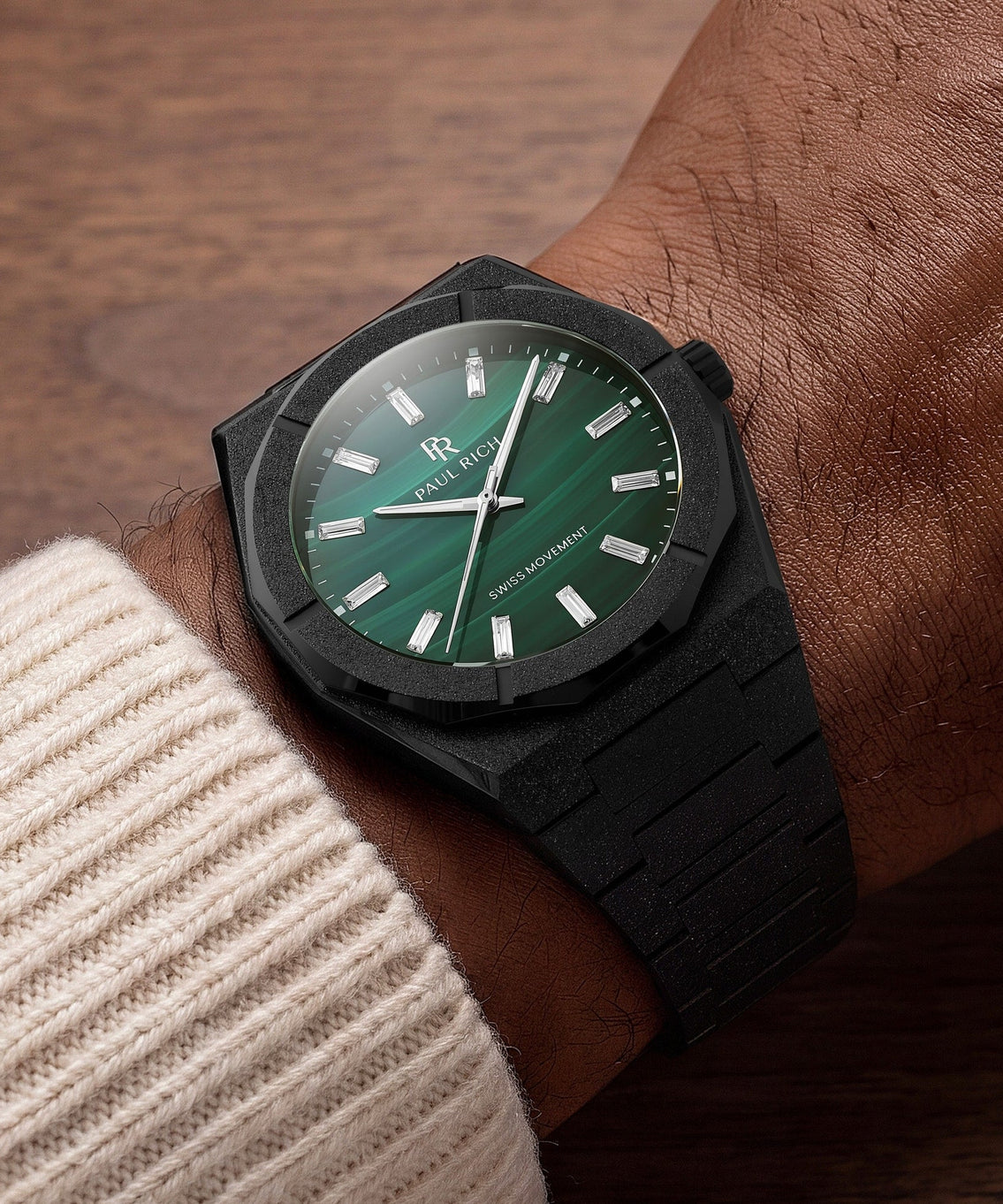 Frosted Star Dust II Malachite Aurora Black, on the wrist against dark wood