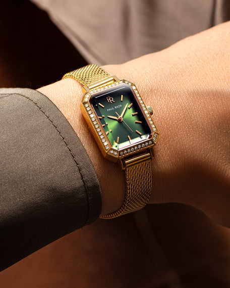Paul Rich Icon watch with gold case and striking green sunburst dial, styled on female wrist.