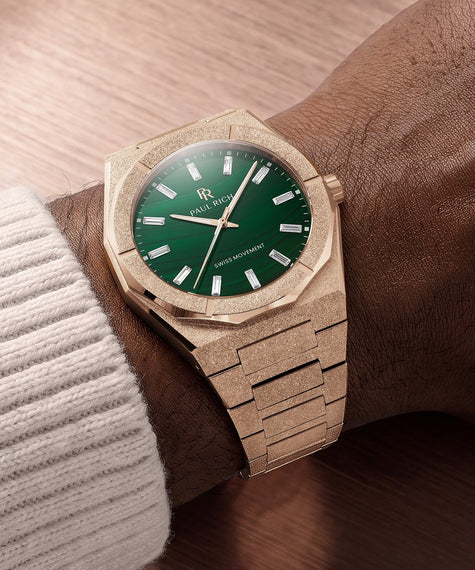 Rose-gold-tone Malachite Aurora watch on a dark skinned wrist against brown background.
