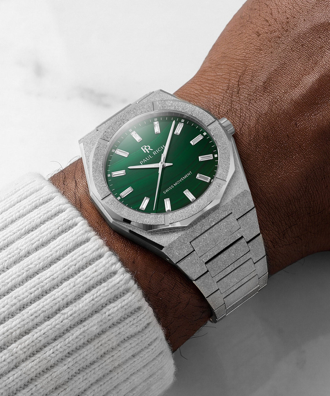 Frosted Star Dust II Malachite Aurora Silver, on the wrist against white marble